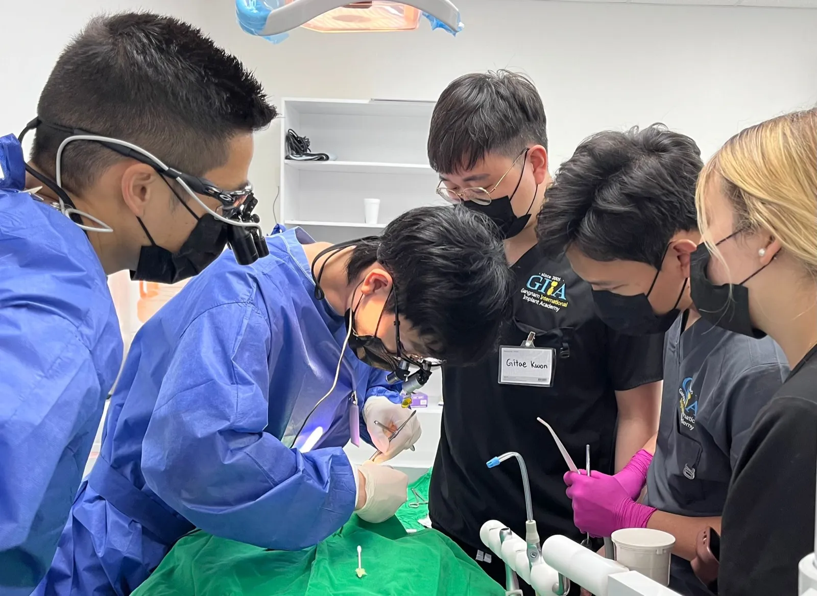 Dr. Kwon watching over a dentist during a live surgery course